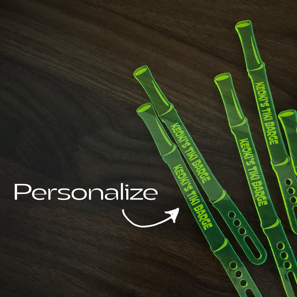 Bamboo Personalized Stubbie Cocktail Stirrers with 'Keoki's Tiki Barge' branding on a dark wooden surface, with text 'Personalize'.