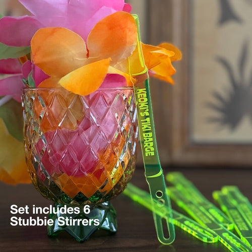 Set of Bamboo Personalized Stubbie Cocktail Stirrers with glass and flowers in the background