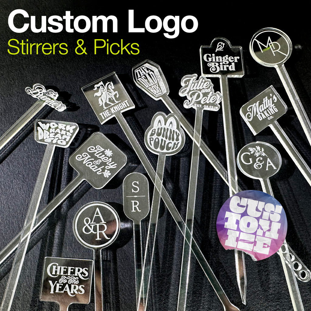 Collection of personalized drink stirrers and custom picks with various custom logos on a dark background.