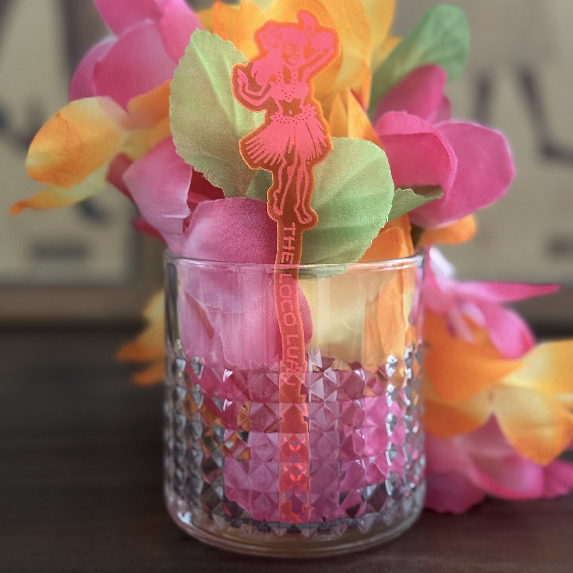 Decorative rocks glass with Hula Dancer "Loco Luau" Personalized Stubbie Swizzle Stick, decorations and flowers.