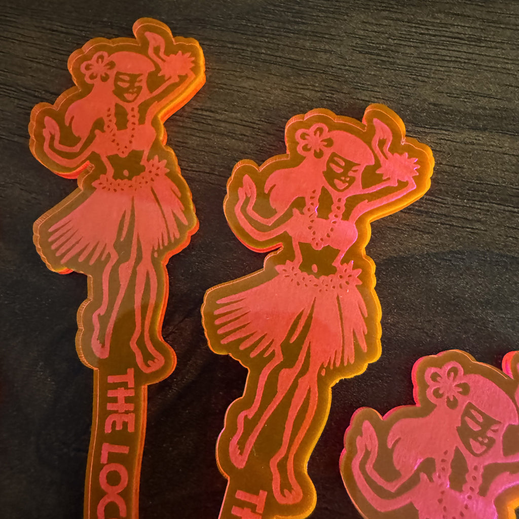 Detail photo of a Hula Dancer "Loco Luau" Personalized XL Swizzle Stick on a dark wooden surface