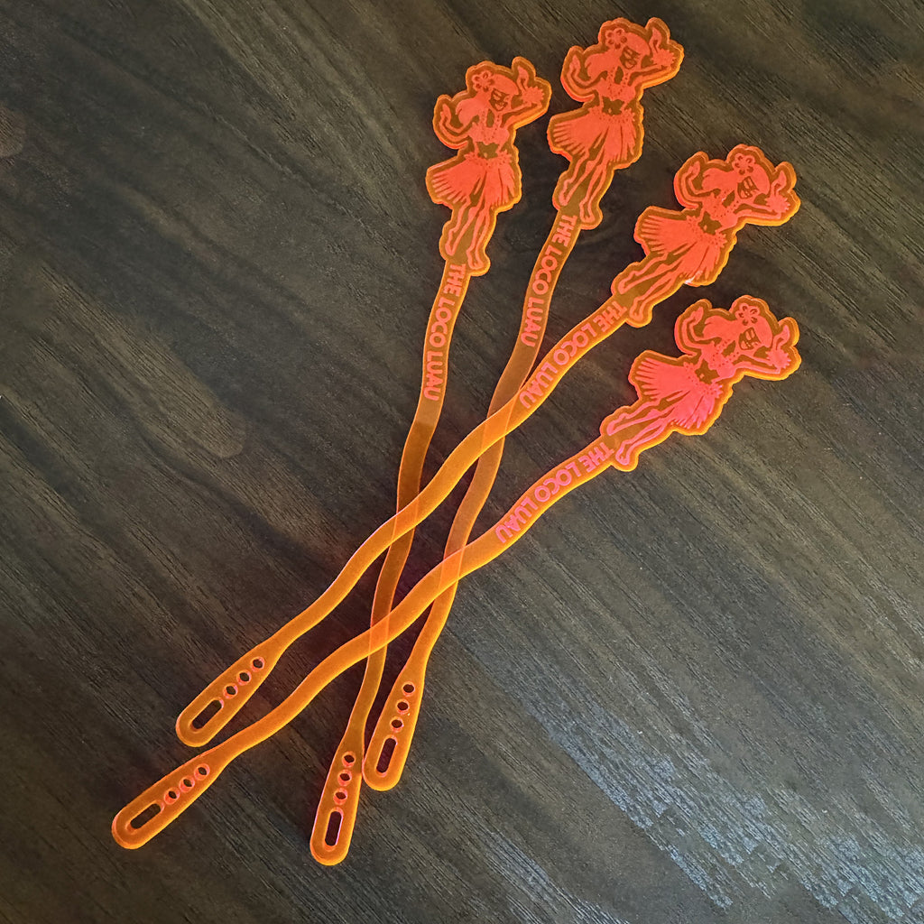 Hula Dancer "Loco Luau" Personalized XL Swizzle Sticks on a dark wooden surface