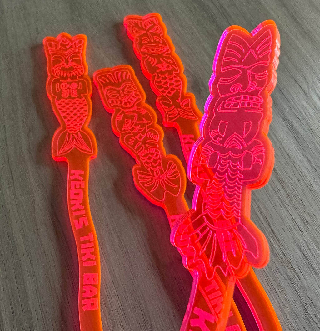Mean Mermaids Personalized XL Swizzle Sticks tiki-themed swizzle sticks on a wooden surface