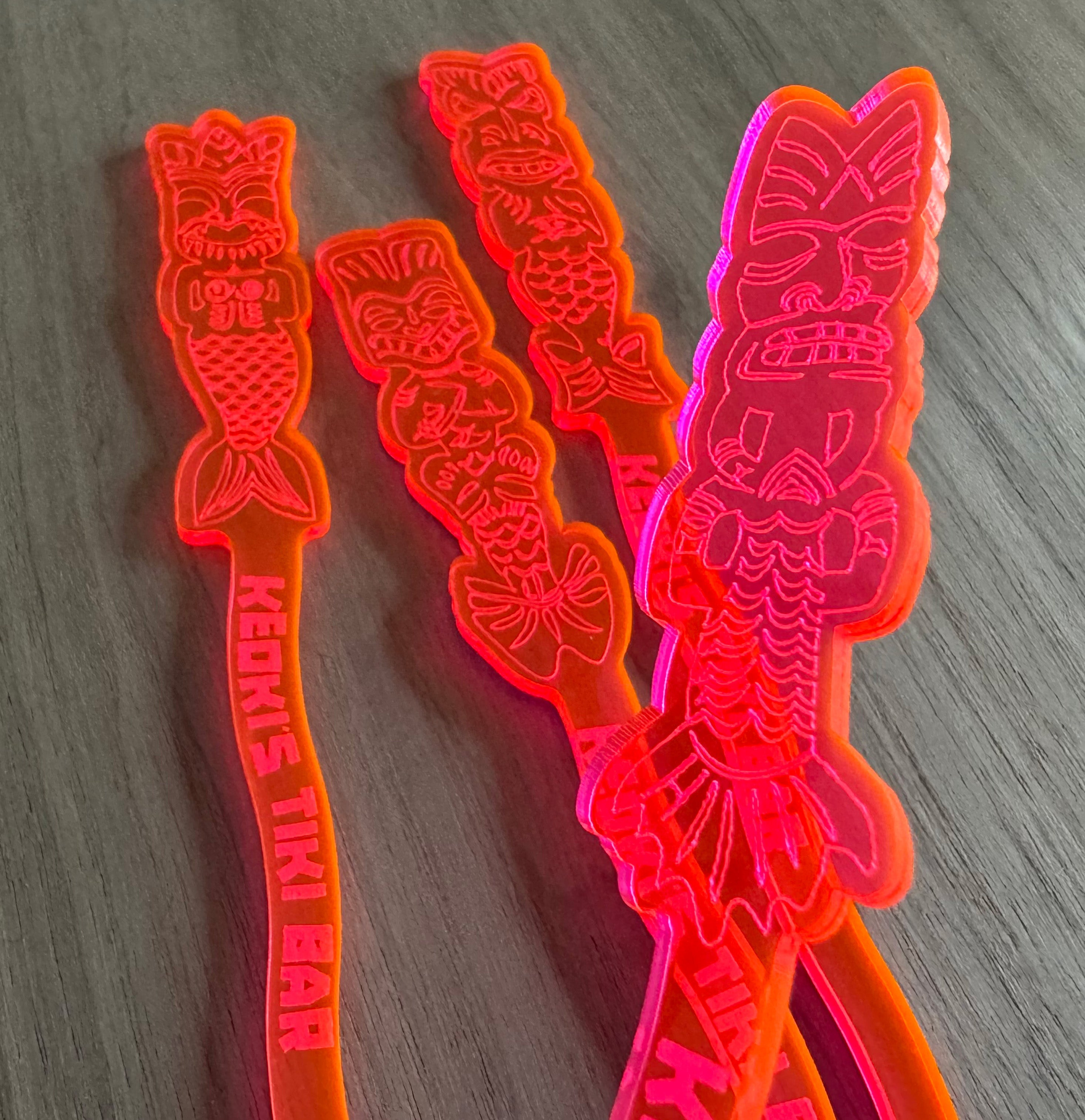 Mean Mermaids Personalized XL Swizzle Sticks tiki-themed swizzle sticks on a wooden surface