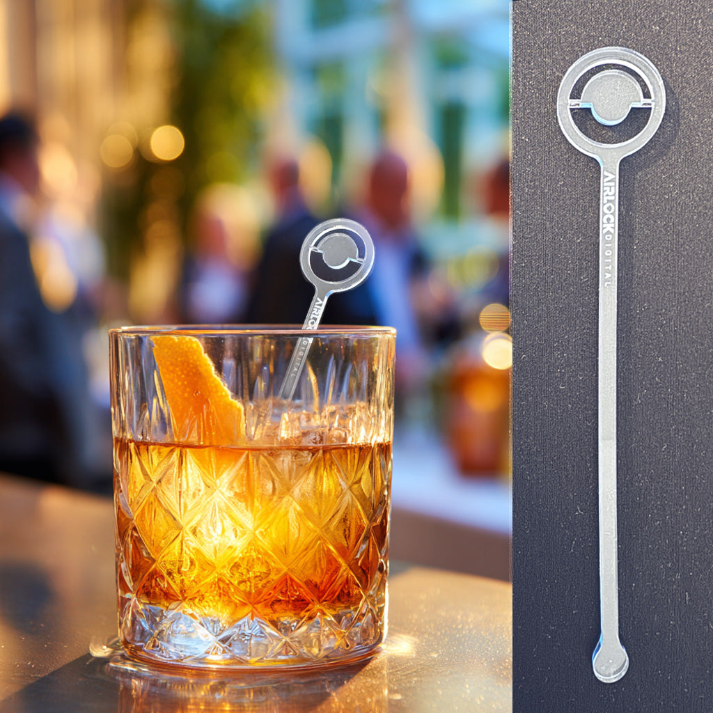 Branded acrylic swizzle stick engraved with Airlock digital logo in a cocktail glass at a business event