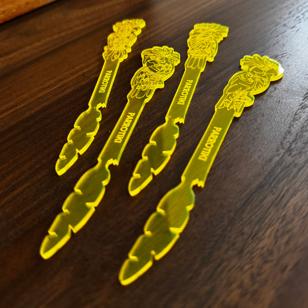 Parrotiki Cocktail Stubbie Stirrer  with parrot engravings, displayed on a dark wooden surface.