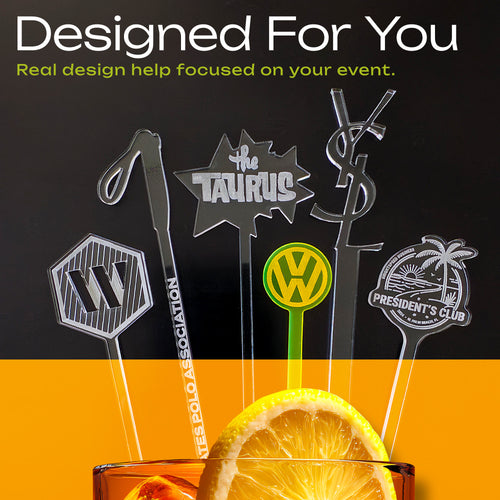 Five clear acrylic cocktail garnish picks with custom designs featuring corporate logos shown in a glass with a lemon slice. The garnish picks feature various brand logos, including a VW logo, a Yacht Club symbol, a Taurus star, a Porsche crest, and a Palm Springs resort sign.