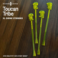 Four translucent neon yellow-green drink stirrers with toucan logo shaped tops are arranged on a dark wood surface. White text on the left reads 'Rivers Caves', 'Toucan Tribe', 'XL Drink Stirrers', and 'STIR CREATIVITY INTO EVERY DRINK'.